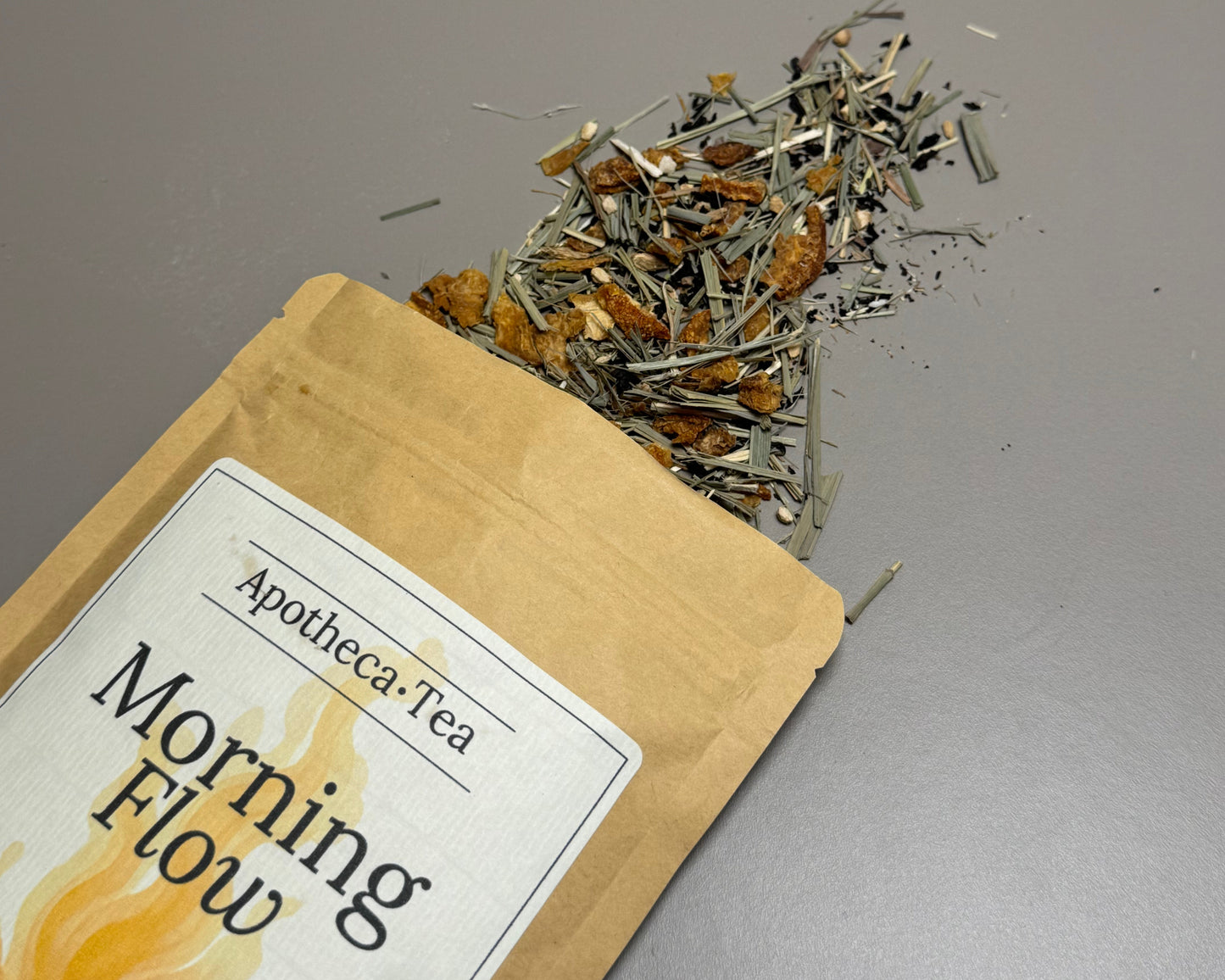Apotheca Tea 'Morning Flow' package with loose tea leaves on a gray background