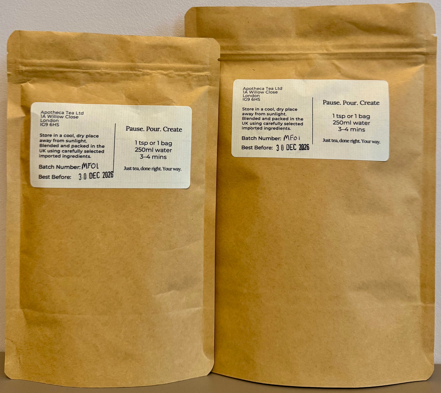 Two brown paper bags with labels on a neutral background